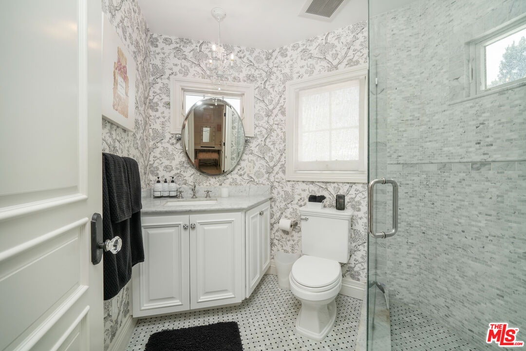 16632 Bienveneda Place Pacific Palisades, CA 90272 - Photo 36 of 62 a bathroom with a toilet a sink and mirror