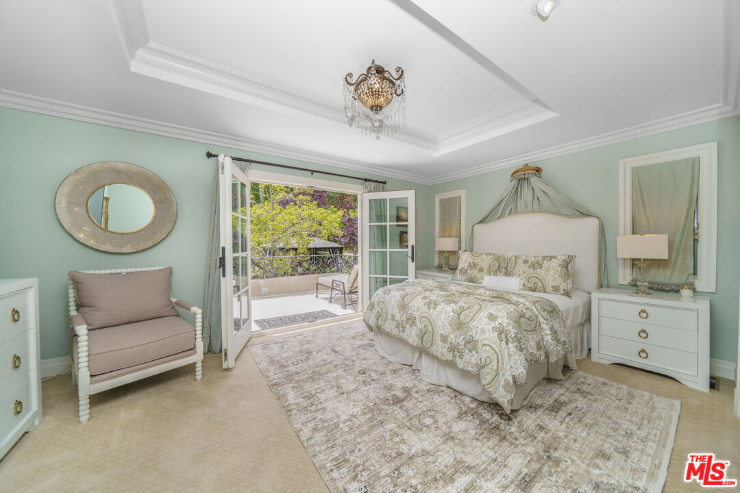 16632 Bienveneda Place Pacific Palisades, CA 90272 - Photo 40 of 62 a bedroom with a large bed and a chandelier