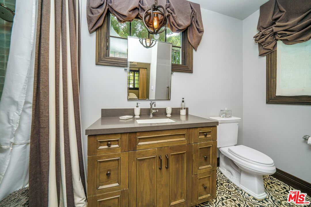 16632 Bienveneda Place Pacific Palisades, CA 90272 - Photo 55 of 62 a bathroom with a toilet a sink and a mirror
