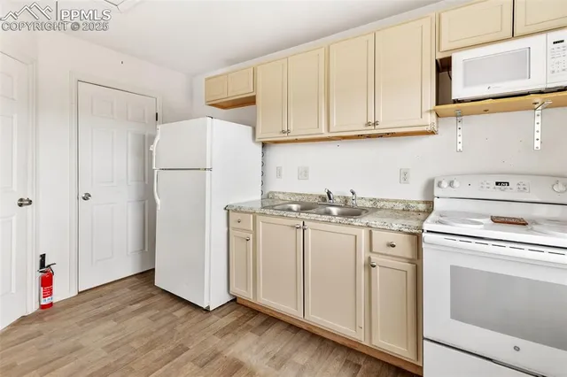a kitchen with a white cabinets and wooden floor