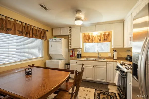 a kitchen with a table chairs sink and cabinets