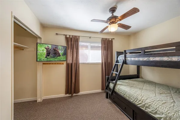 a bedroom with a bed and a ceiling fan
