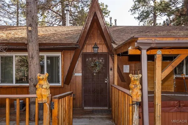 a view of a house with wooden fence and a tree
