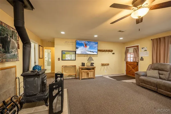 a living room with furniture a flat screen tv and kitchen view