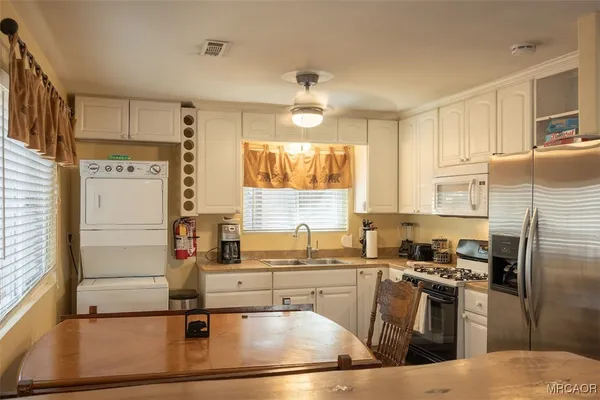 a kitchen with kitchen island granite countertop a sink appliances and cabinets