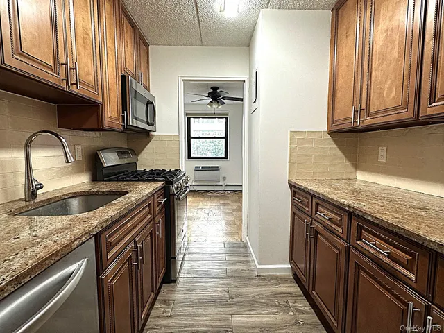 a kitchen with granite countertop cabinets stainless steel appliances a sink and a counter space