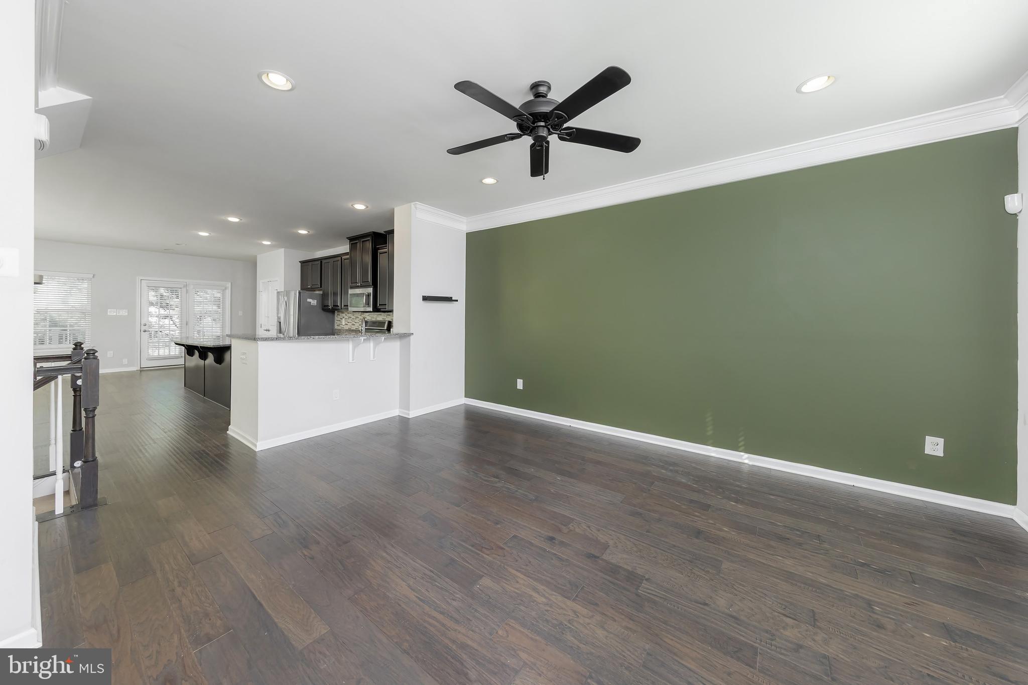 1036 Regency Place Sewell, NJ 08080 - Photo 7 of 18 a view of a livingroom with a kitchen space a ceiling fan and wooden floor