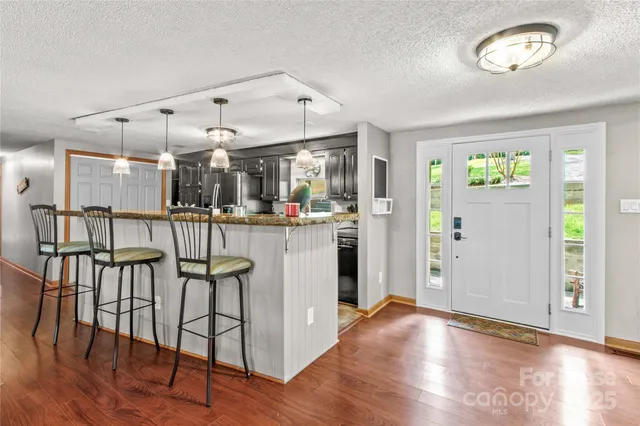 a kitchen with stainless steel appliances kitchen island hardwood floor and a window