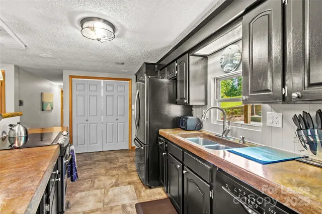 a kitchen with stainless steel appliances granite countertop a sink stove and cabinets