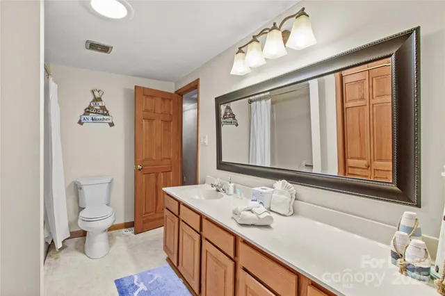 a bathroom with a granite countertop sink mirror vanity and toilet