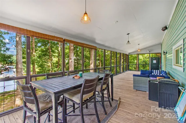 a view of a dining room with furniture large windows and wooden floor