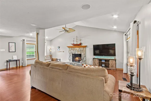 a living room with furniture a flat screen tv and a fireplace