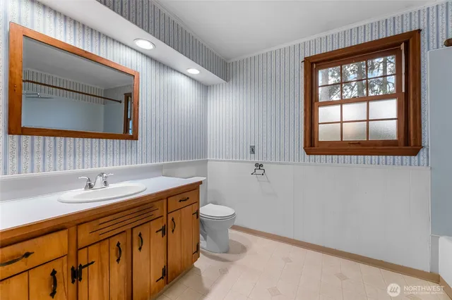 a bathroom with a sink a toilet and mirror
