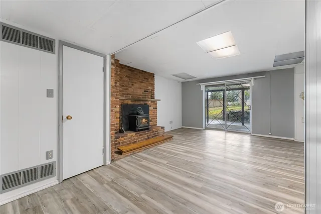 a view of empty room with wooden floor and fireplace
