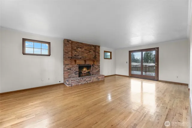 a view of empty room with wooden floor and fireplace