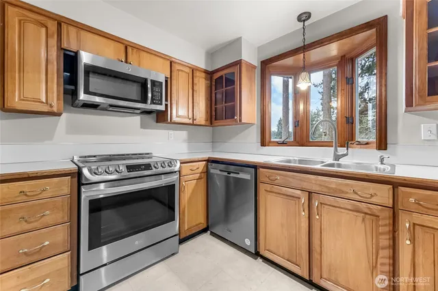 a kitchen with stainless steel appliances granite countertop a stove microwave and sink