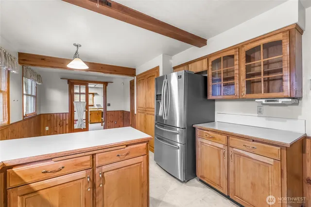 a kitchen with kitchen island a counter top space a sink stainless steel appliances and cabinets