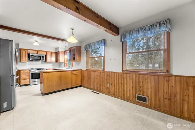 a large kitchen with stainless steel appliances granite countertop a stove a sink dishwasher and a refrigerator with wooden floor