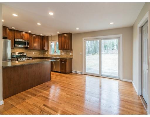 18 Pamela Road Framingham, MA 01701 - Photo 4 of 20 a kitchen with stainless steel appliances granite countertop a stove top oven a sink dishwasher a refrigerator and a dining table with wooden floor