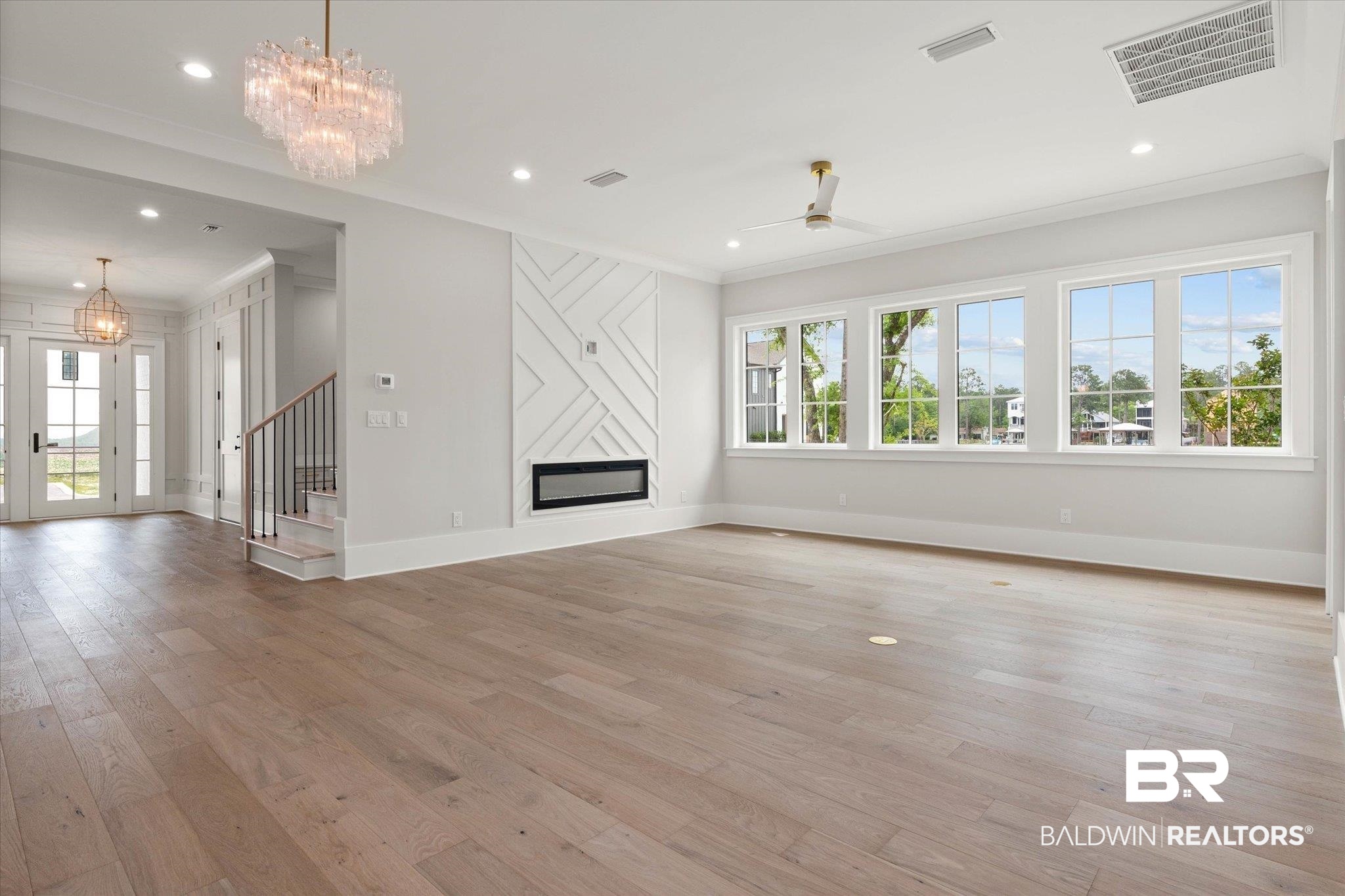 853 Inlet Circle Gulf Shores, AL 36542 - Photo 7 of 55 Unfurnished living room with visible vents, ornamental molding, baseboards, and a glass covered fireplace