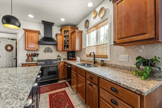 a kitchen with stainless steel appliances granite countertop a stove a sink and a refrigerator