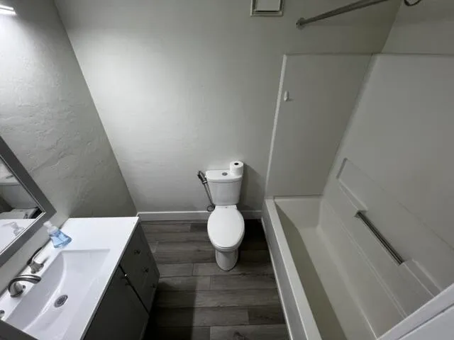 a bathroom with a toilet sink and mirror