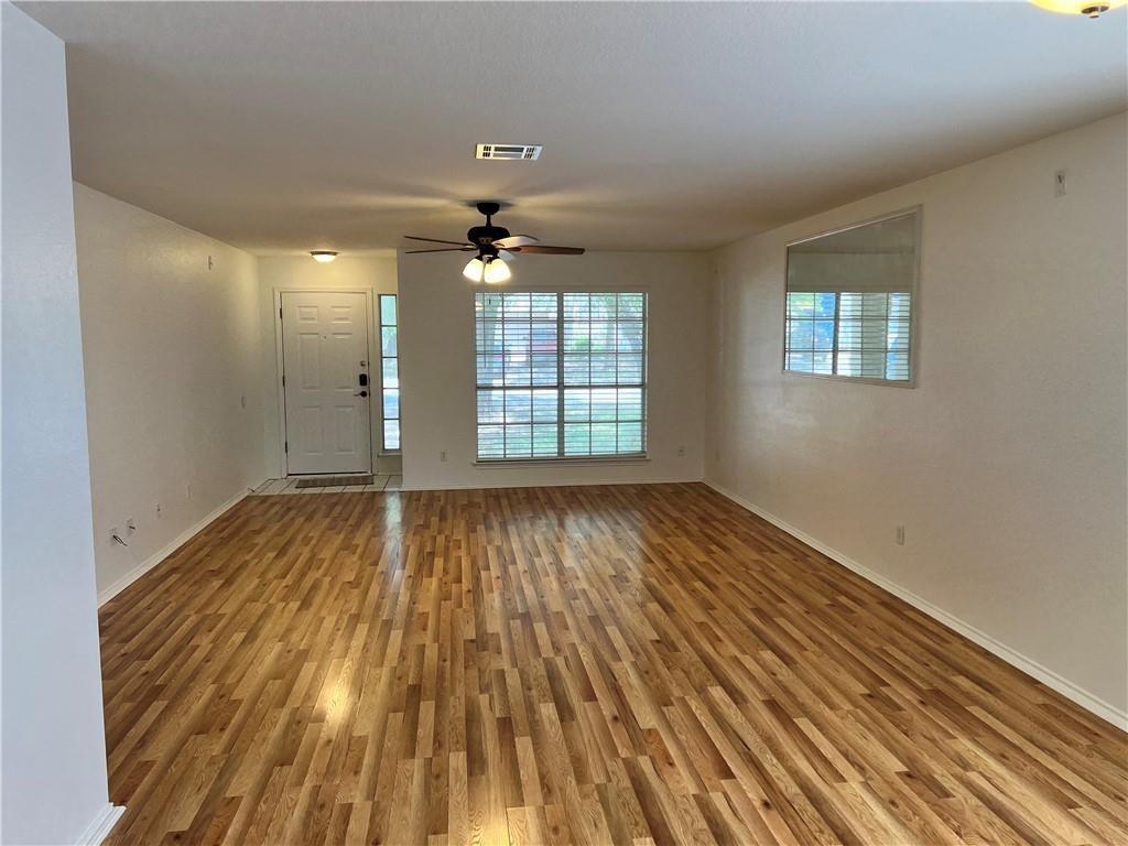 17312 Manish Drive Pflugerville, TX 78660 - Photo 3 of 19 an empty room with wooden floor and windows