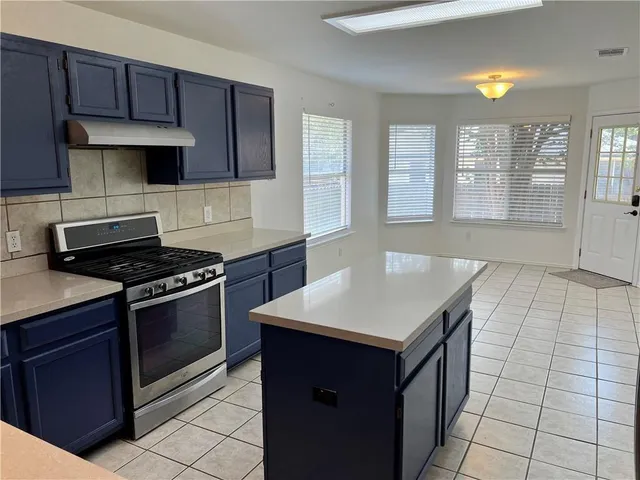 a kitchen with a stove cabinets and a refrigerator