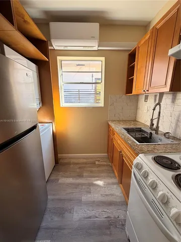 a kitchen with sink a refrigerator and a stove