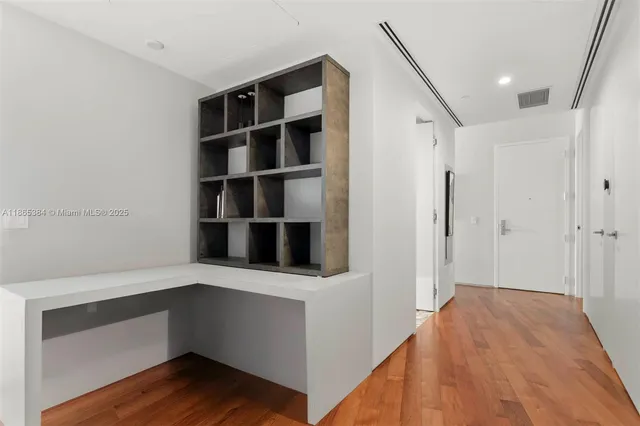 a bedroom with a bed and a flat tv screen on dresser