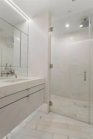 a walk in closet and view of bathroom