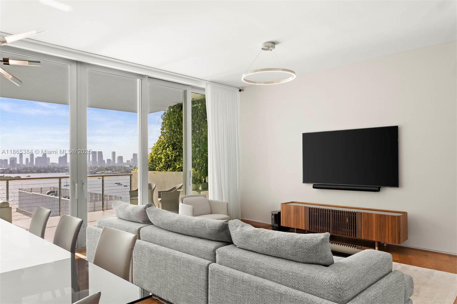 1300 Monad Terrace, Unit 11C Miami Beach, FL 33139 - Photo 26 of 29 a living room with furniture a flat screen tv and a floor to ceiling window