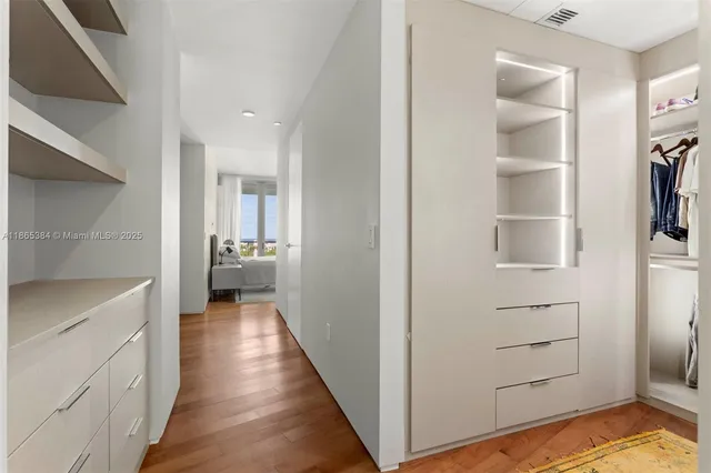 a view of a hallway with wooden floor and closet