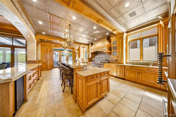 a large kitchen with stainless steel appliances granite countertop a large window and a wooden floors