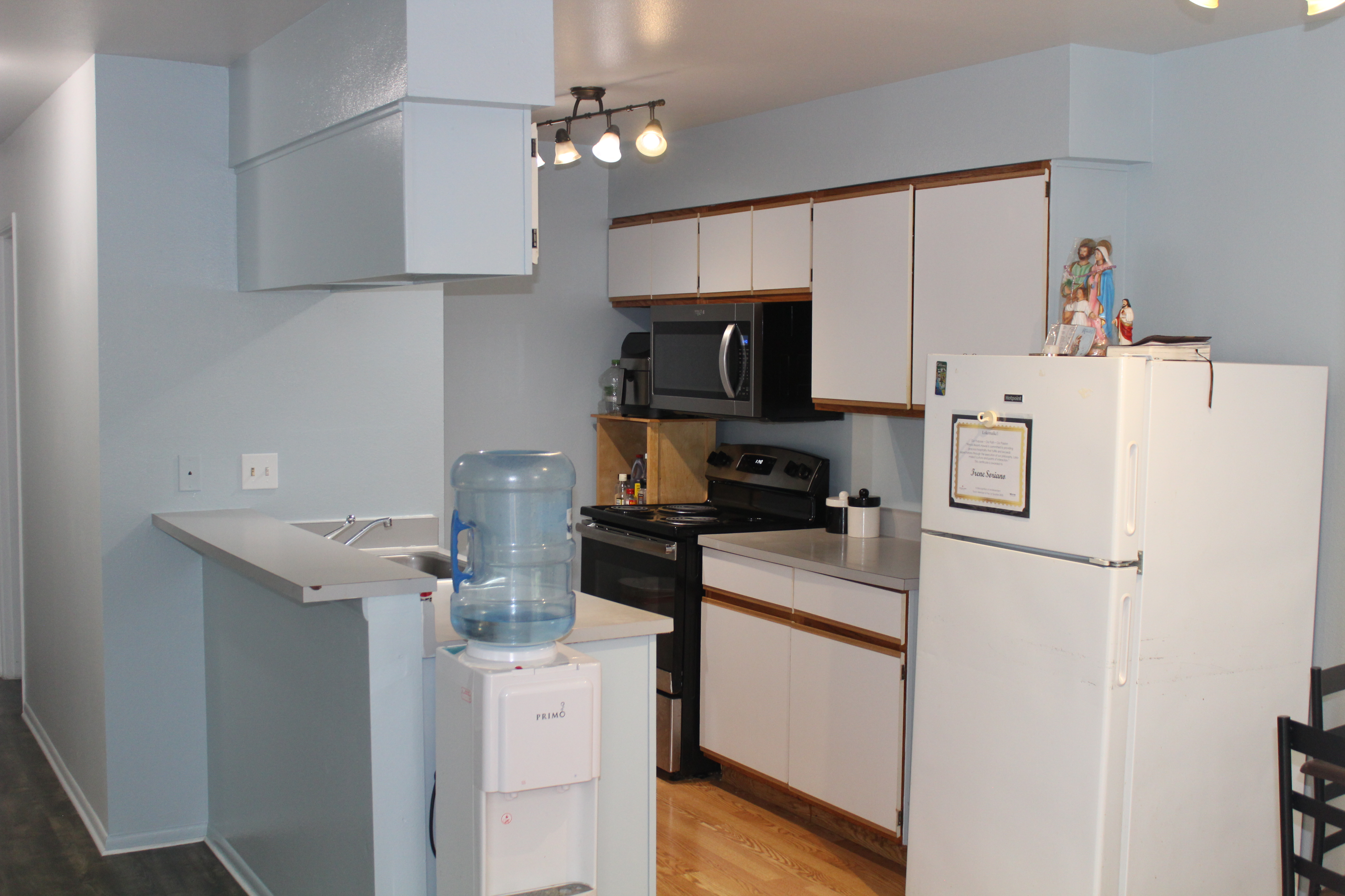 68-3831 Lua Kula Street, Unit L107 Waikoloa, HI 96738 - Photo 3 of 17 a kitchen with stainless steel appliances a refrigerator stove and white cabinets