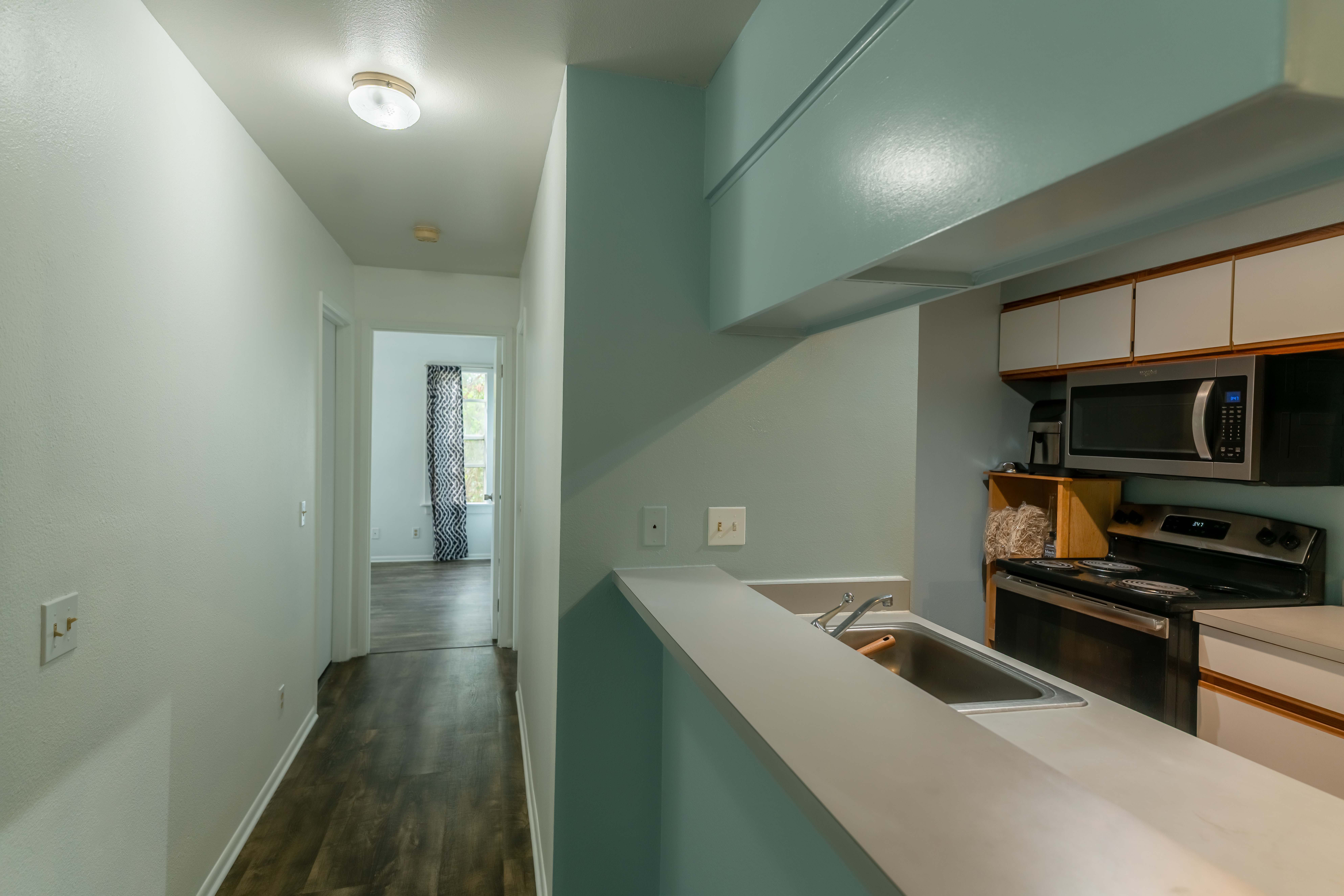 68-3831 Lua Kula Street, Unit L107 Waikoloa, HI 96738 - Photo 4 of 17 a hallway with a stove and a refrigerator