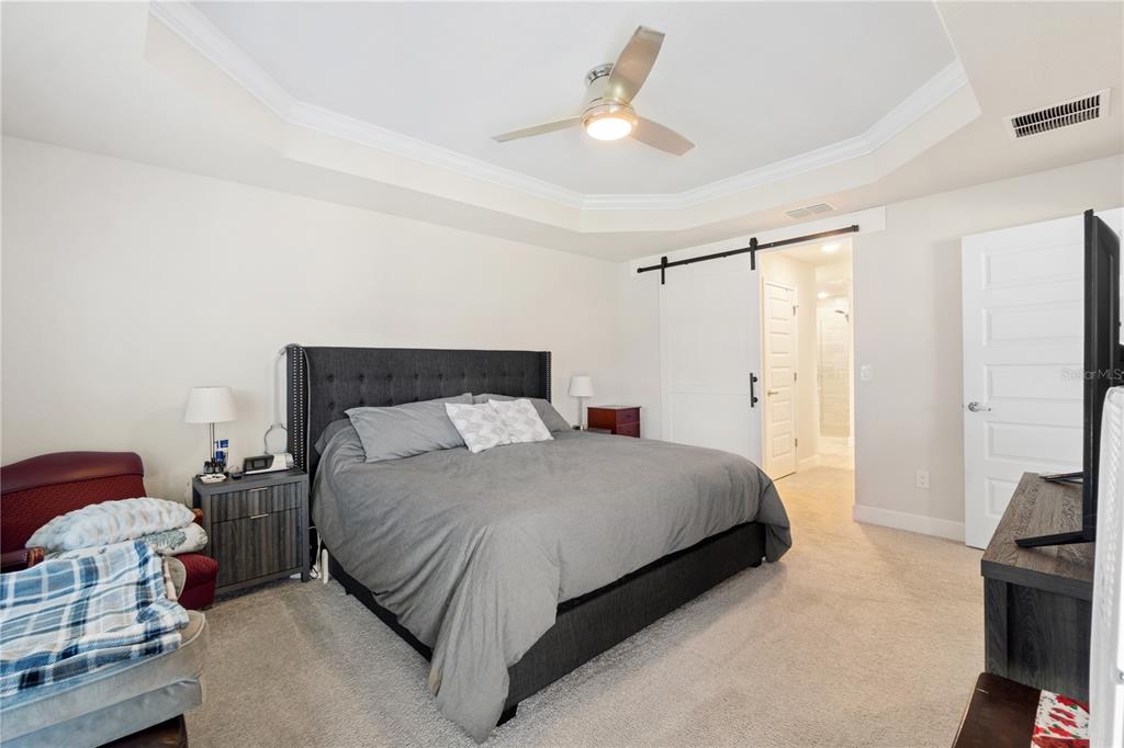 10170 Southwest 78th Court Ocala, FL 34476 - Photo 11 of 43 a bedroom with a bed and a chandelier