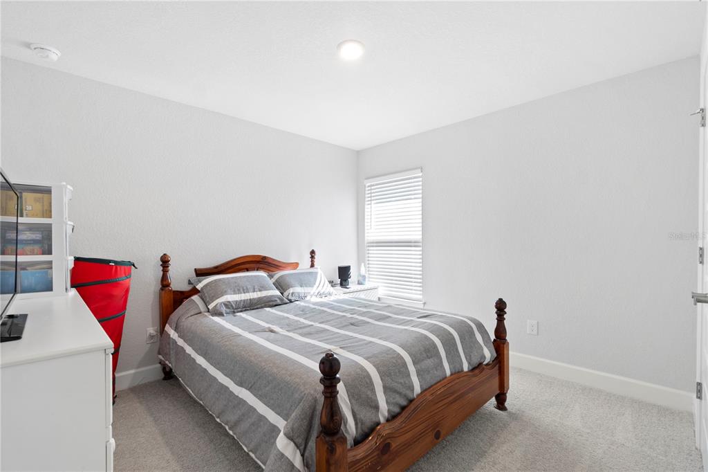 10170 Southwest 78th Court Ocala, FL 34476 - Photo 12 of 43 a bedroom with a bed and a dresser