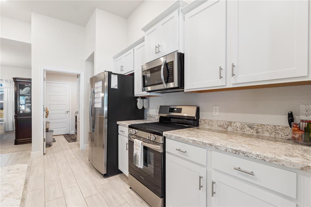 10170 Southwest 78th Court Ocala, FL 34476 - Photo 19 of 43 a kitchen with stainless steel appliances granite countertop a stove a refrigerator and a white cabinets