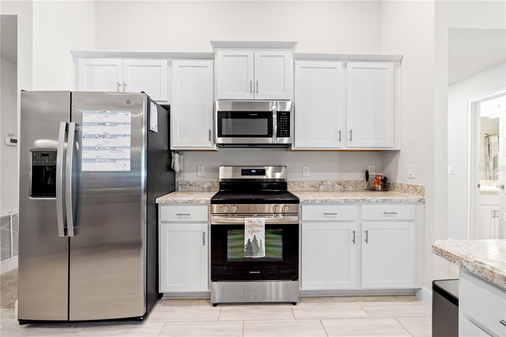 10170 Southwest 78th Court Ocala, FL 34476 - Photo 22 of 44 a kitchen with a stove microwave and refrigerator