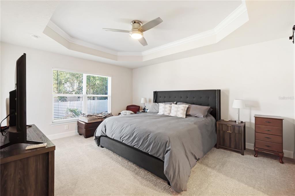 10170 Southwest 78th Court Ocala, FL 34476 - Photo 23 of 43 a bedroom with a bed a large window and flat screen tv