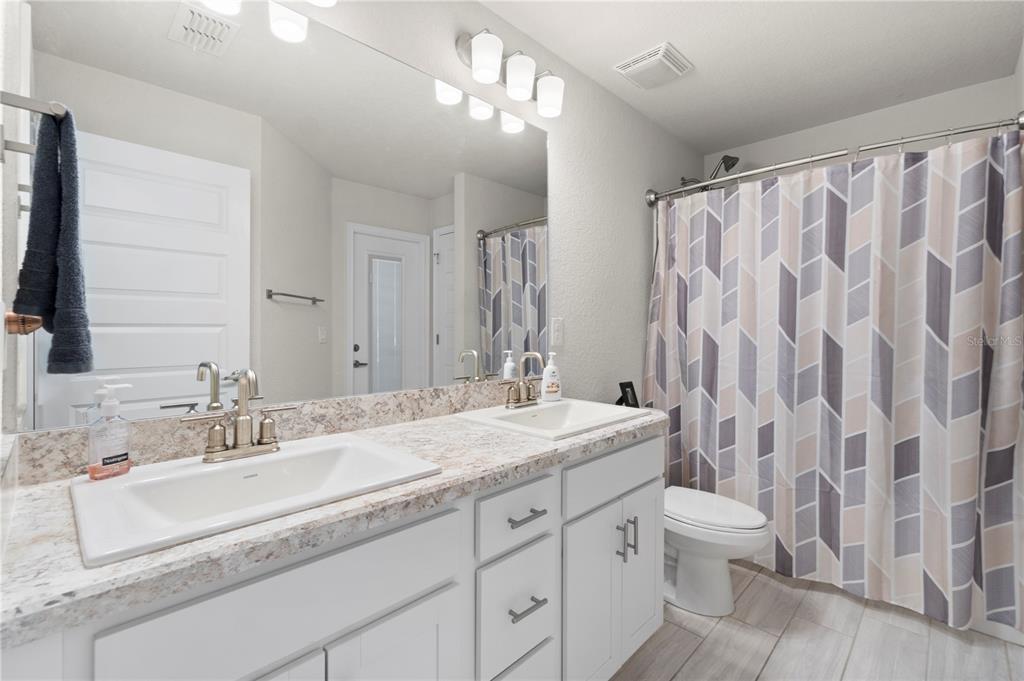 10170 Southwest 78th Court Ocala, FL 34476 - Photo 29 of 43 a bathroom with a double vanity sink toilet and a mirror