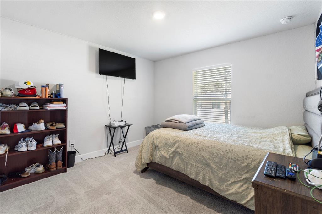 10170 Southwest 78th Court Ocala, FL 34476 - Photo 30 of 43 a bedroom with a bed and a flat screen tv