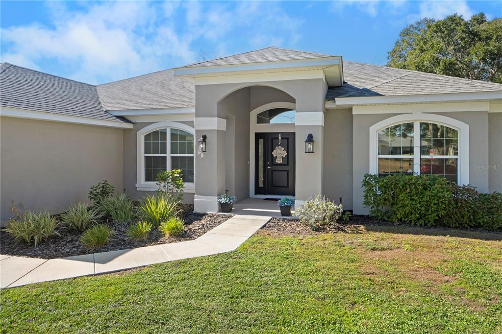 10170 Southwest 78th Court Ocala, FL 34476 - Photo 3 of 43 a front view of a house with garden