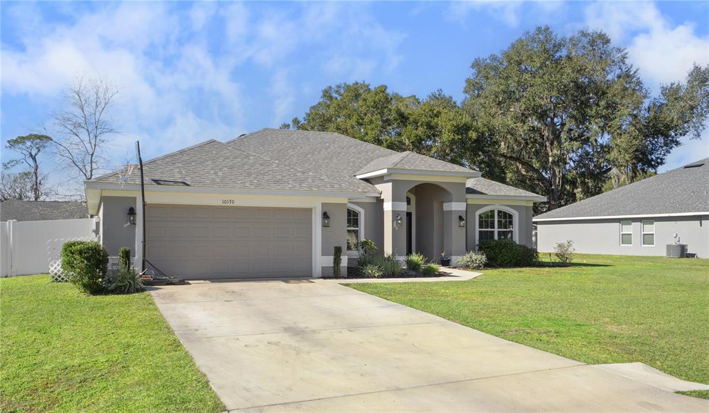 10170 Southwest 78th Court Ocala, FL 34476 - Photo 32 of 43 a front view of a house with a yard and garage