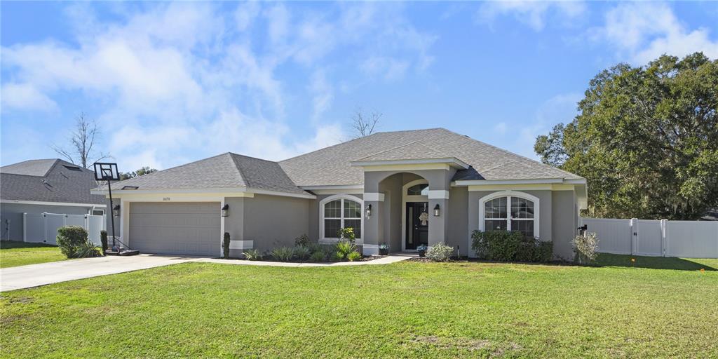 10170 Southwest 78th Court Ocala, FL 34476 - Photo 33 of 43 a front view of a house with a yard and garage
