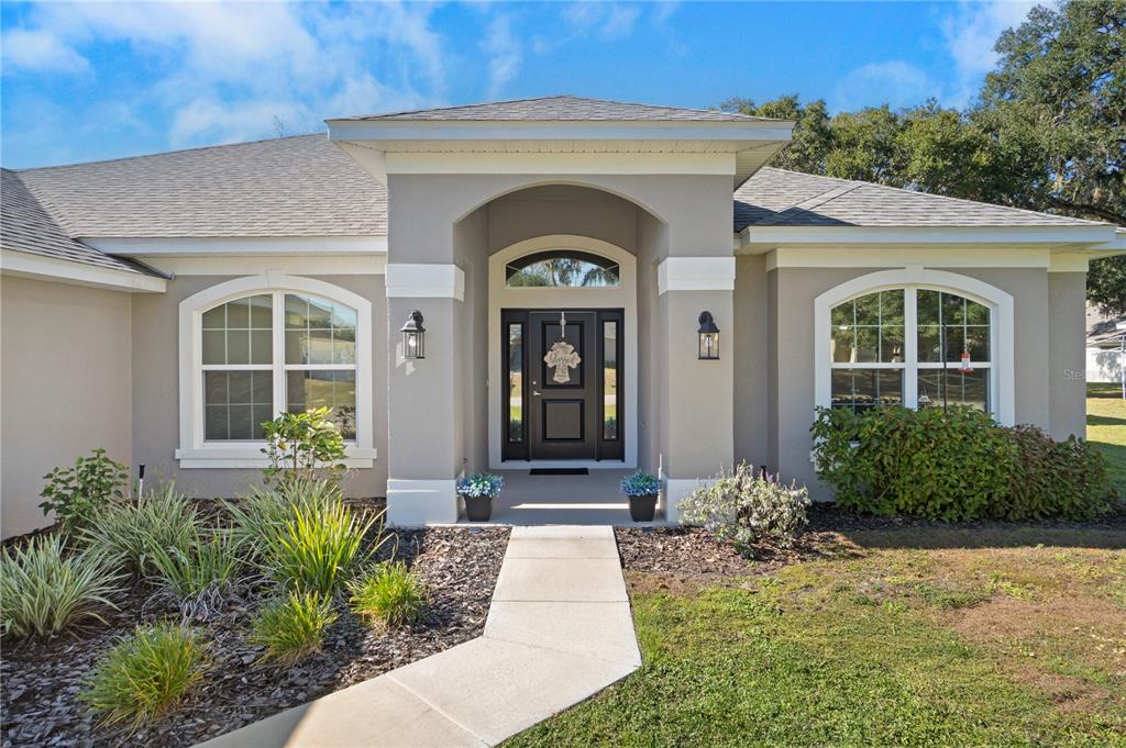 10170 Southwest 78th Court Ocala, FL 34476 - Photo 4 of 44 a front view of a house with garden