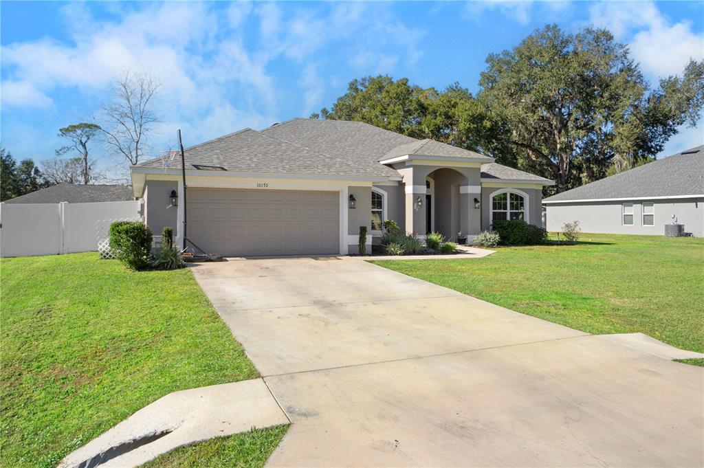 10170 Southwest 78th Court Ocala, FL 34476 - Photo 7 of 43 a front view of a house with a yard and trees