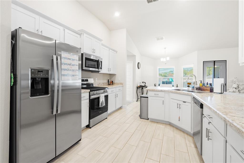 10170 Southwest 78th Court Ocala, FL 34476 - Photo 7 of 44 a kitchen with white cabinets and stainless steel appliances