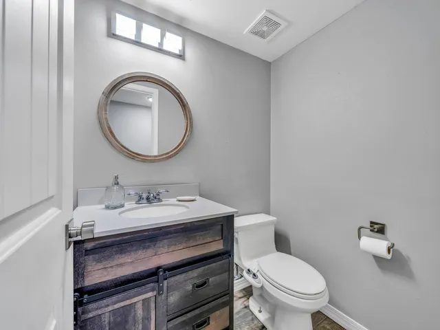 a bathroom with a toilet a sink and a mirror